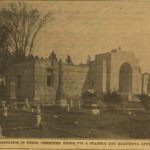 Sepia toned photograph of inside a cemetery with a large mausoleum