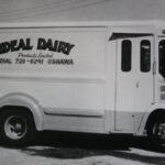 Black and white photo of a white van. It has the words 'Ideal Dairy' printed on the side