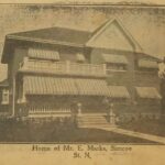 Sepia toned photo of a house, featuring awnings over each window and a large porch. Writing underneath the photo says 'Home of Mr. E. Marks. Simcoe St. N.'