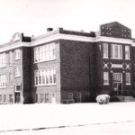 Black and white picture of a three-story brick building taken from the side