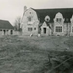 Black and white photo of a house, appearing to be in a state of construction as there is no lawn in front