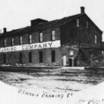 Black and white photograph of a building with a sign reading Oshawa Canning Company