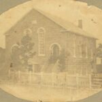 Sepia toned photo of a church with rounded windows and rounded doorways