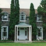 Colour photograph of a stone house, with a central front porch
