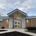 Colour photo of a doorway into a brick building with big windows