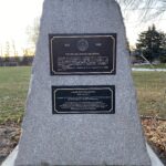 Colour photo of a bronze plaque embedded in a grey stone