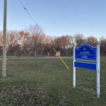 Colour photo of a park, with a blue sign reading "Chopin Park"